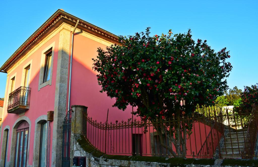 uma casa cor-de-rosa com uma árvore em frente em Casas Marias de Portugal - Cerveira em Vila Nova de Cerveira