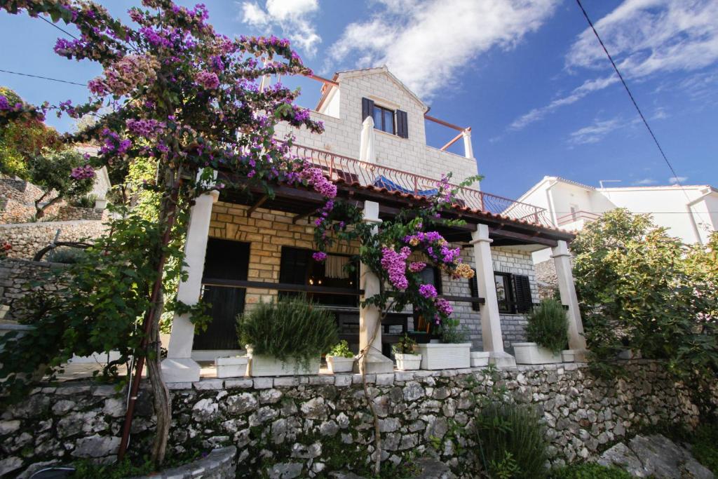 una casa con flores en una pared de piedra en Vila Agazio, en Gornje Selo
