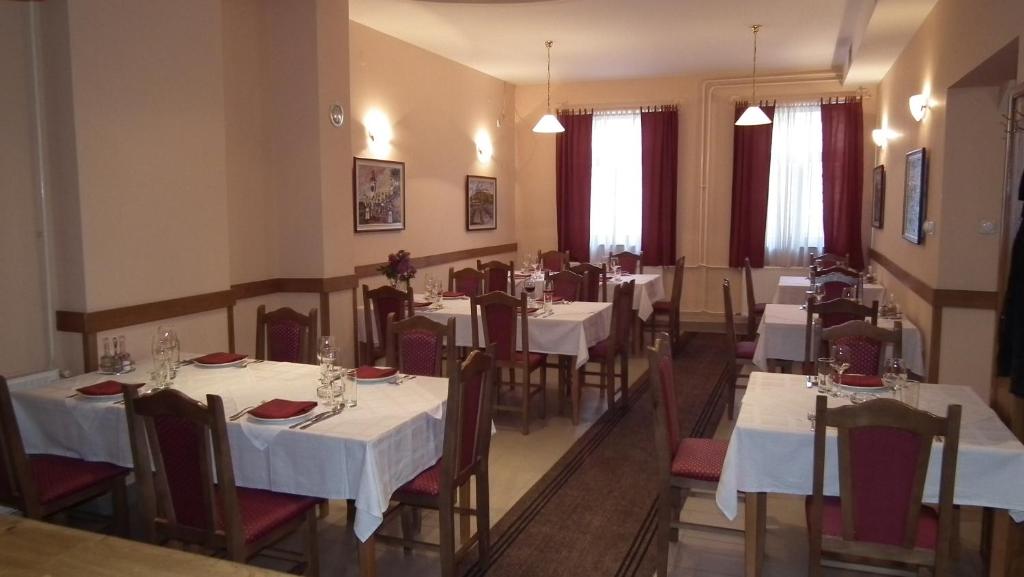 a restaurant with tables and chairs with white tablecloths at Naša Tvrđava Guest Accommodation in Novi Sad