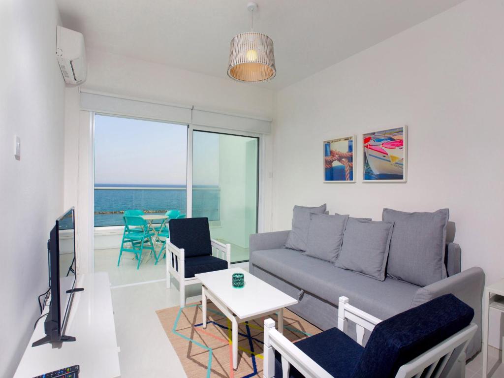 a living room with a couch and a table at On The Beach Penthouse by TrulyCyprus in Limassol