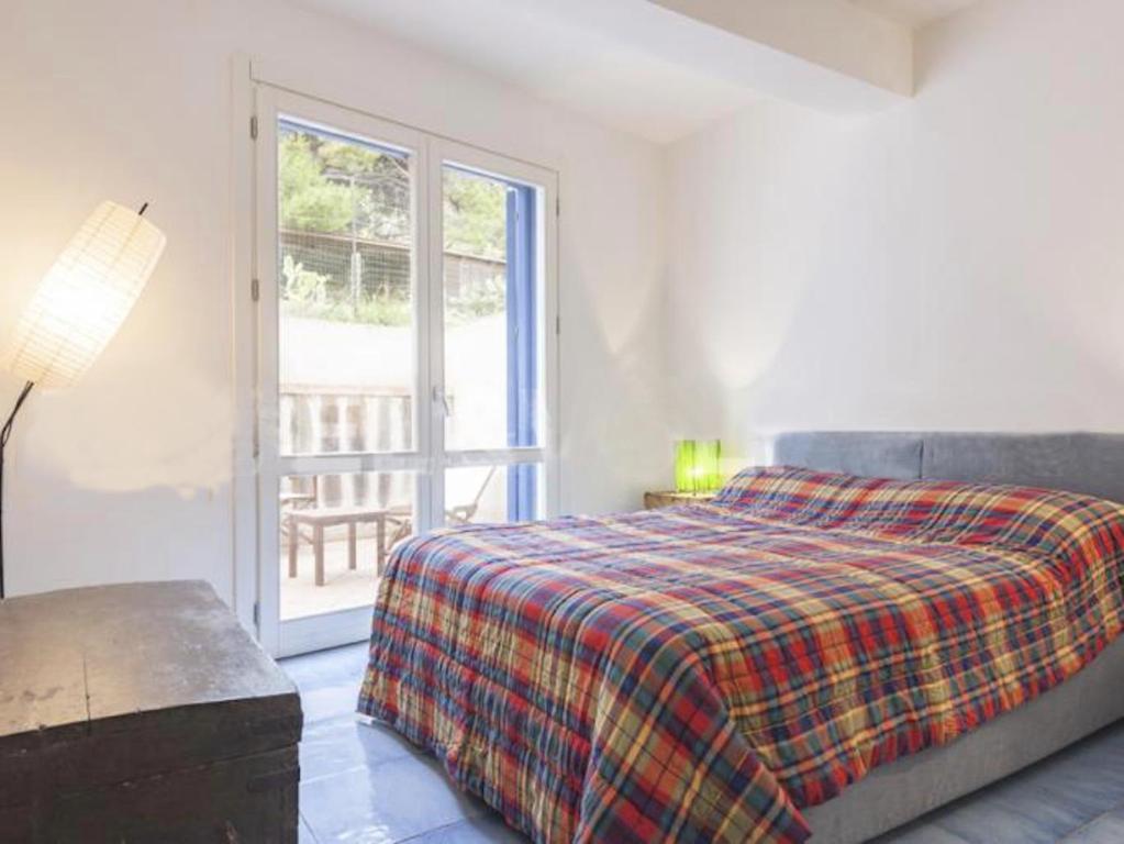 WeLive Marettimo - luxury loft في ماريتيمو: غرفة نوم بسرير وباب زجاجي منزلق