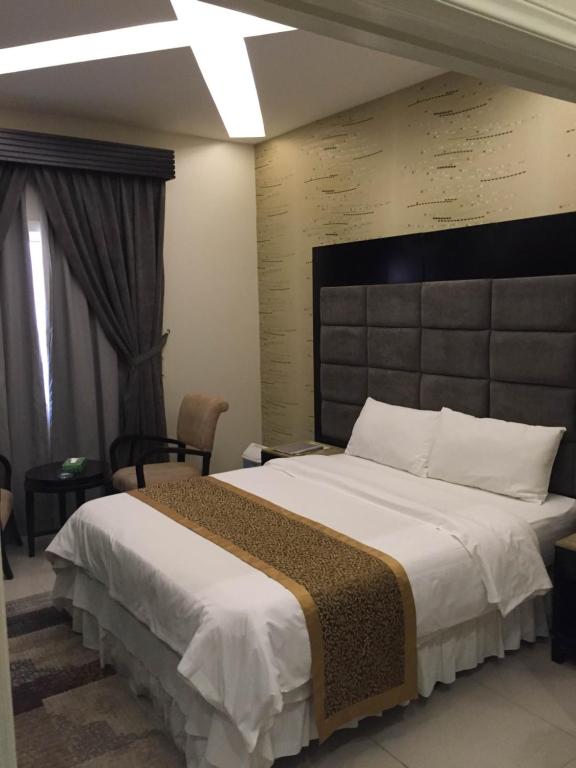 1 dormitorio con 1 cama grande y cabecero grande en Rukon Buotat 15, en Riad