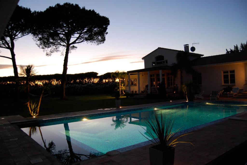 a swimming pool in front of a house at night at Mas Roubel in Saint-Gilles