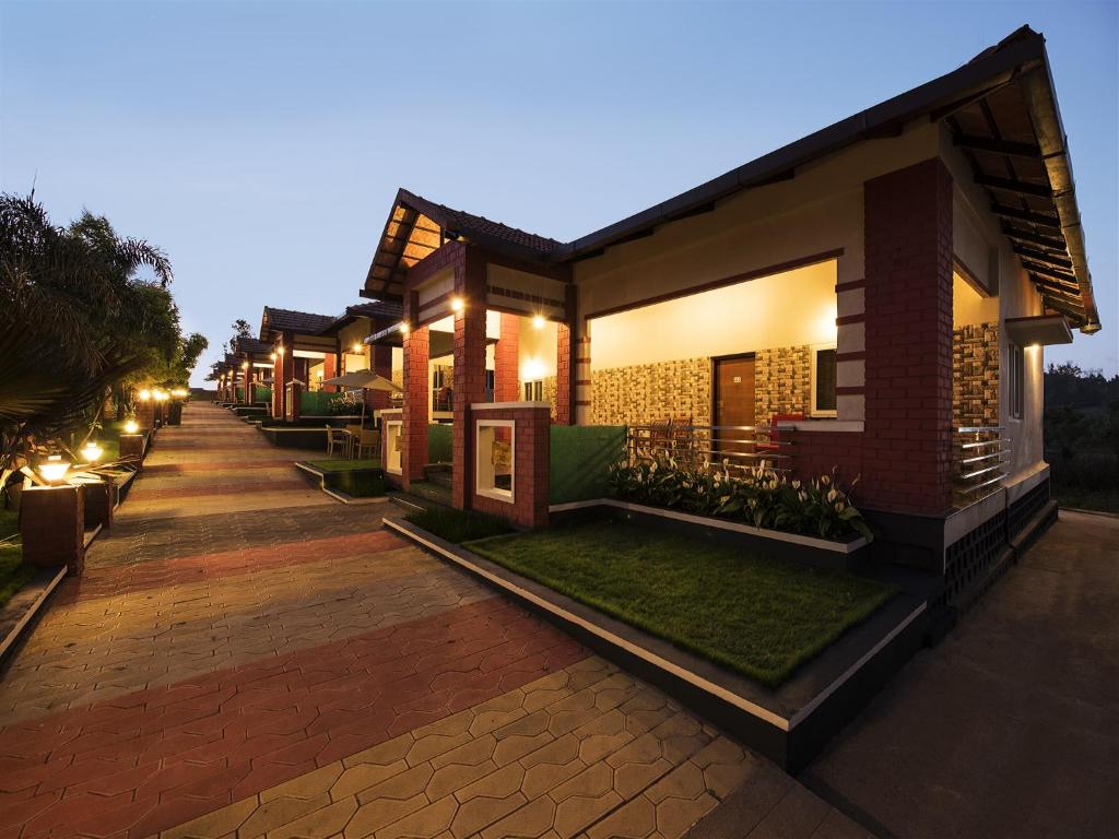 una fila de casas por la noche con luces en Woodstock Resorts en Madikeri