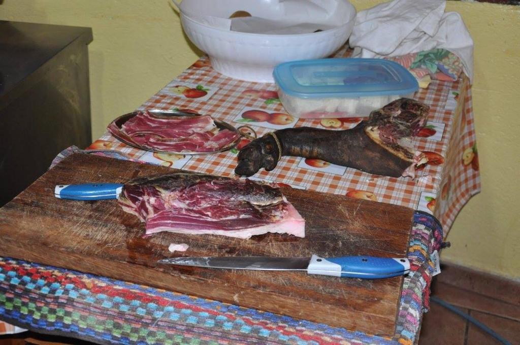 Agriturismo S'Armidda في Seùlo: لوحة تقطيع مع اللحوم وسكين على الطاولة