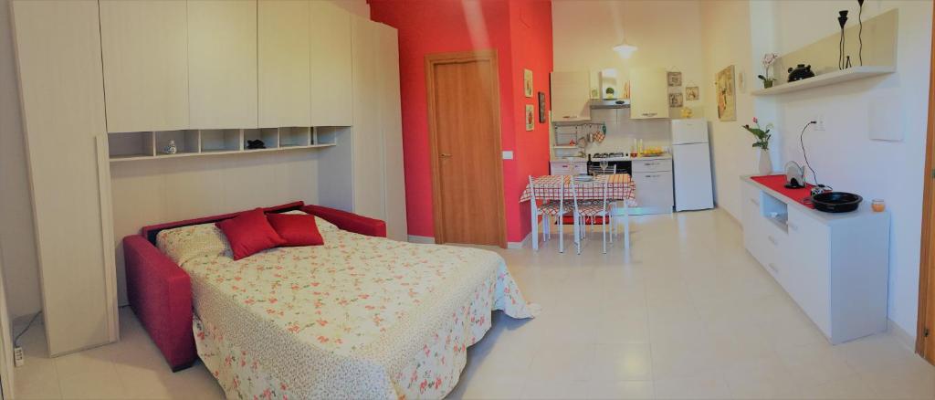 ノートにあるCasa del Torchioのベッドルーム1室(赤い枕のベッド1台付)、キッチンが備わります。