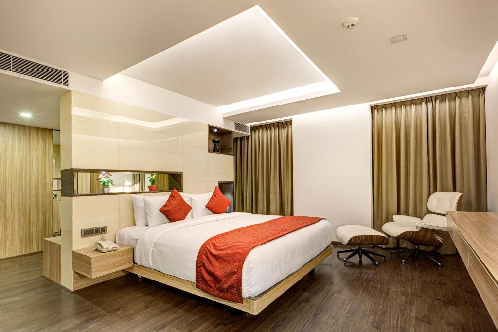a hotel room with a bed and a desk at Attide Hotel in Bangalore