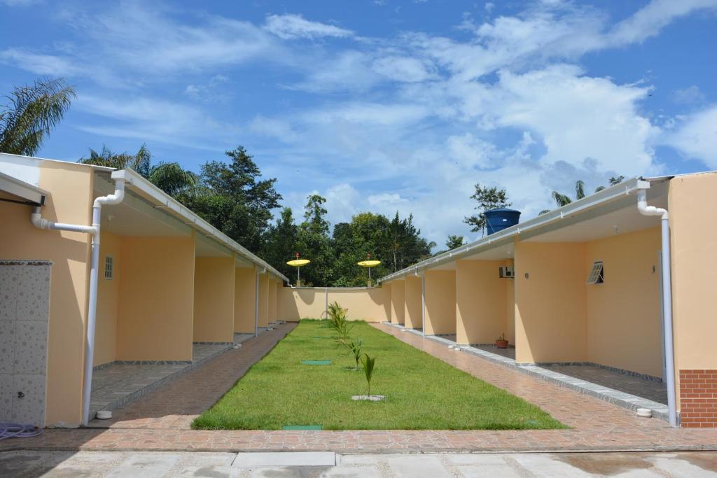 a row of barracks with grass between them at Pousada Recanto Das Garças in Rio Preto Da Eva