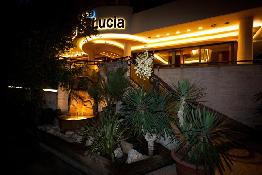un ristorante con piante in vaso di fronte a un edificio di Hotel Santa Lucia a Bibione