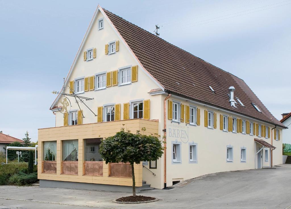 un gran edificio blanco con un árbol delante en Hotel Landgasthof Bären, en Trossingen