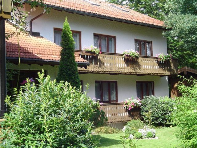 ein Haus mit Blumentöpfen auf den Balkonen in der Unterkunft Hotel am Wald in Ottobrunn