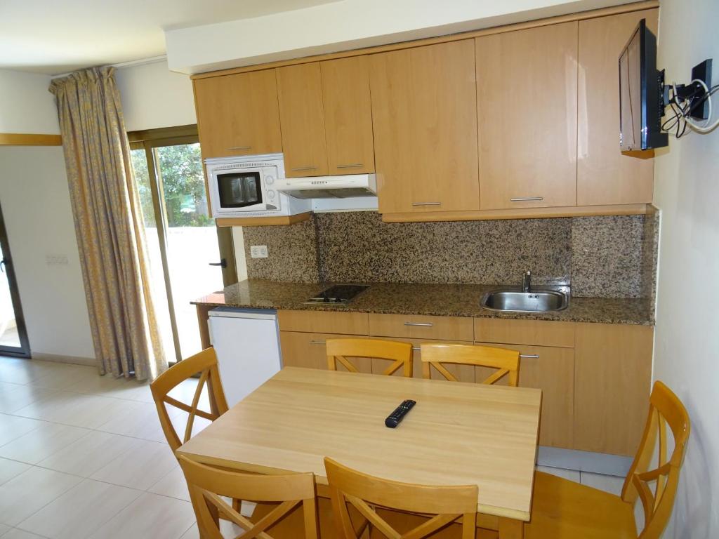 - une cuisine avec une table et des chaises en bois dans l'établissement Apartamentos Selvapark, à Lloret de Mar
