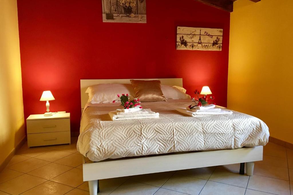 una camera da letto con un letto con pareti rosse e due lampade di Al Duomo a Partinico