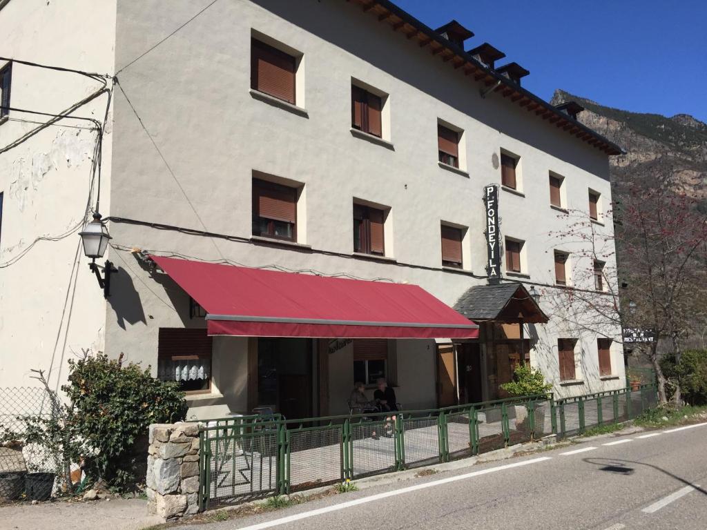 a building with a red awning in front of it at Hostal Fondevila in Bohí