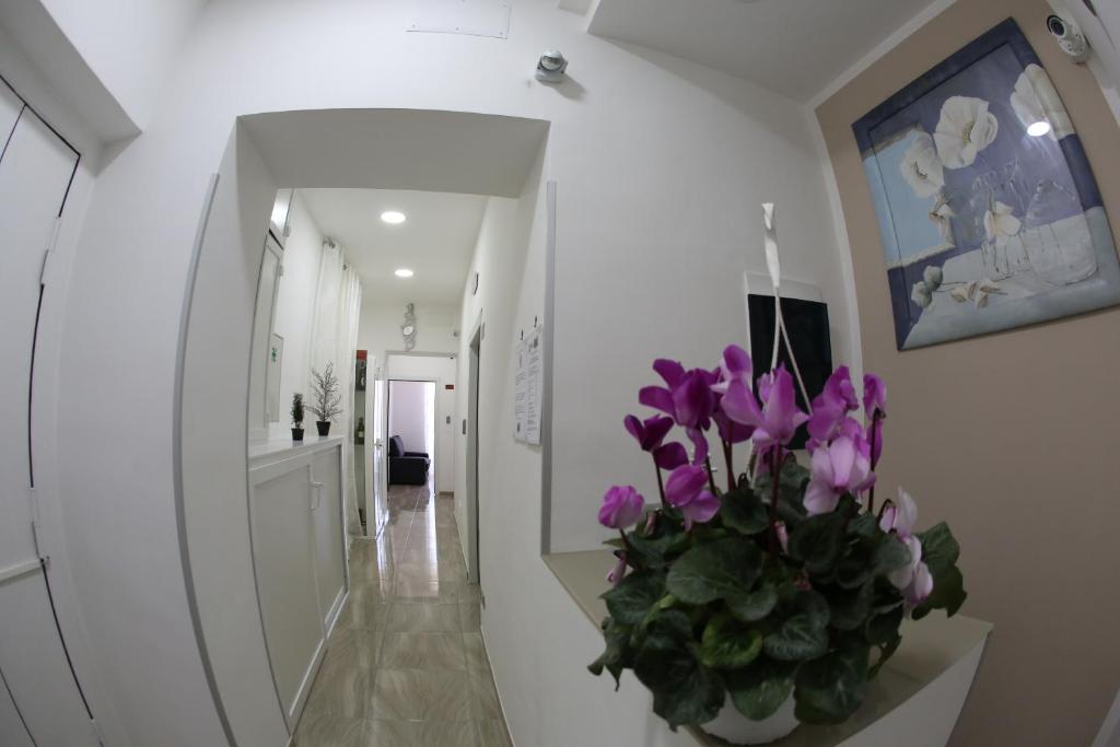 a hallway with a vase with purple flowers in it at Ville Vesuviane in San Giorgio a Cremano