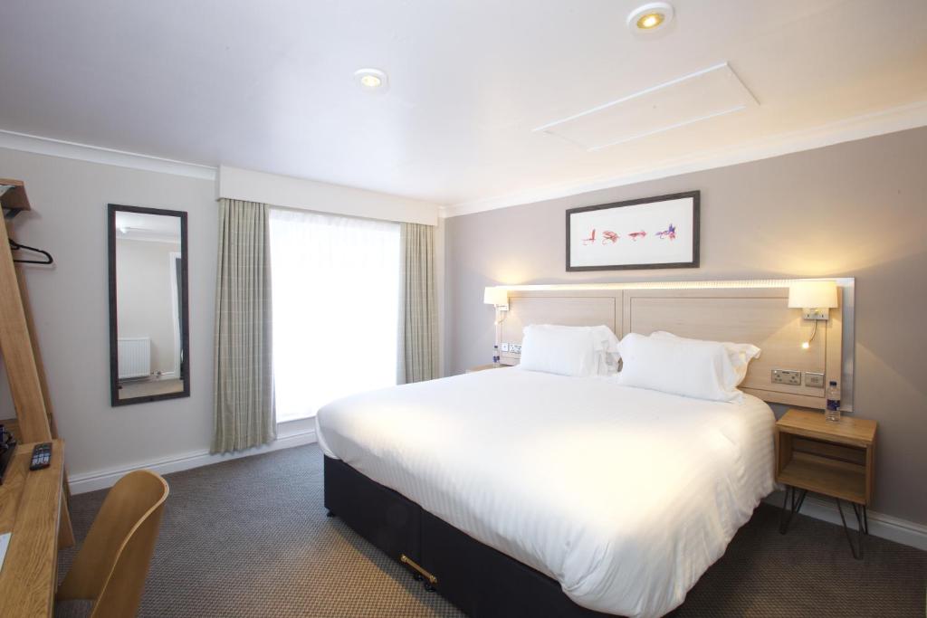 a hotel room with a large bed and a window at Fisherman's Cot, Tiverton by Marston's Inns in Tiverton