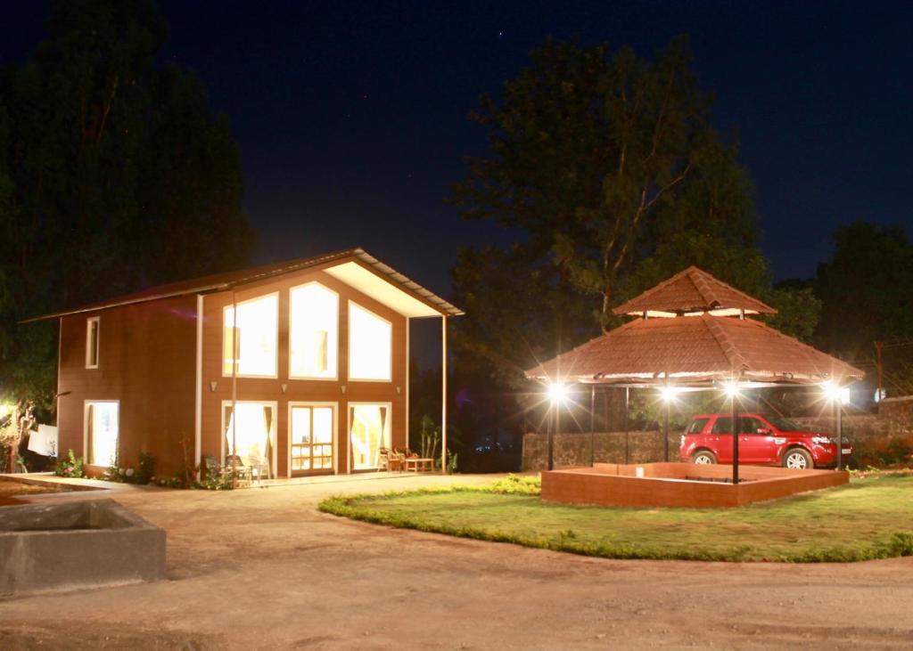 a house with a car parked in front of it at night at Lotus Farms (Pure Veg) in Mahabaleshwar