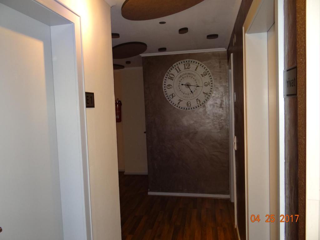 un couloir avec une horloge sur le mur dans l'établissement Hotel h4 easy, à Eschweiler