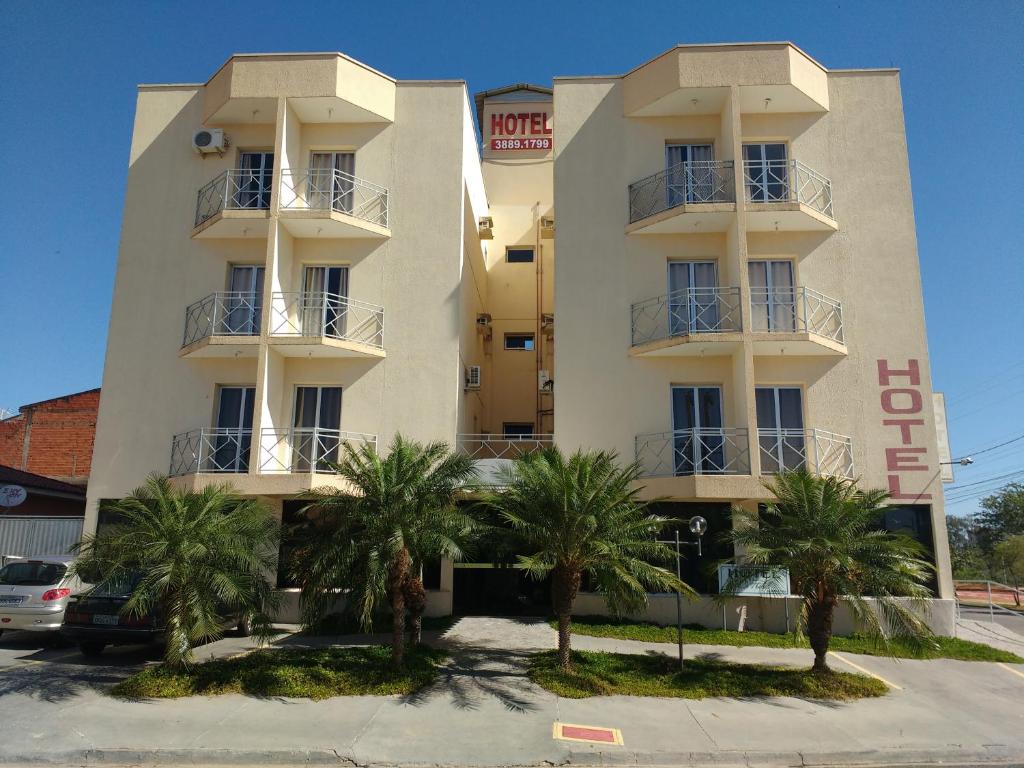 ein weißes Gebäude mit Palmen davor in der Unterkunft Hotel Di Fratelli in Monte Mor