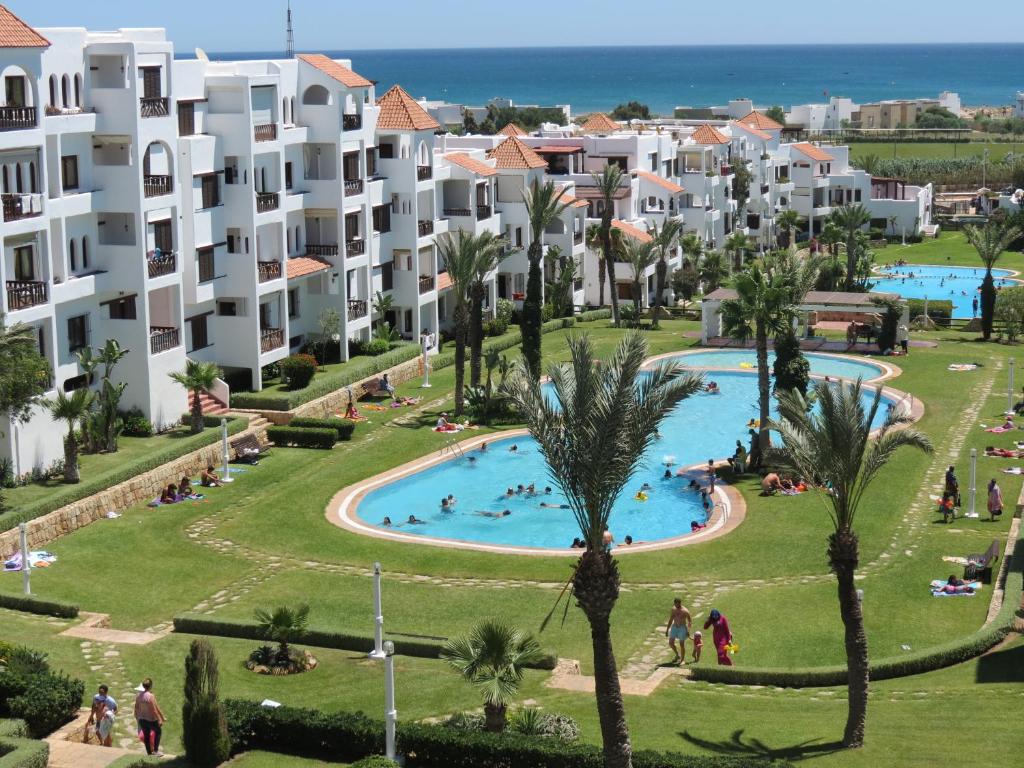 een luchtzicht op een resort met een zwembad en palmbomen bij Résidence familiale "Les Jardins de Cabo" in Cabo Negro