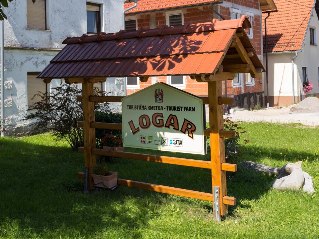 ein Schild mit einem Dach auf einem Haus in der Unterkunft Turistična Kmetija Logar in Grahovo