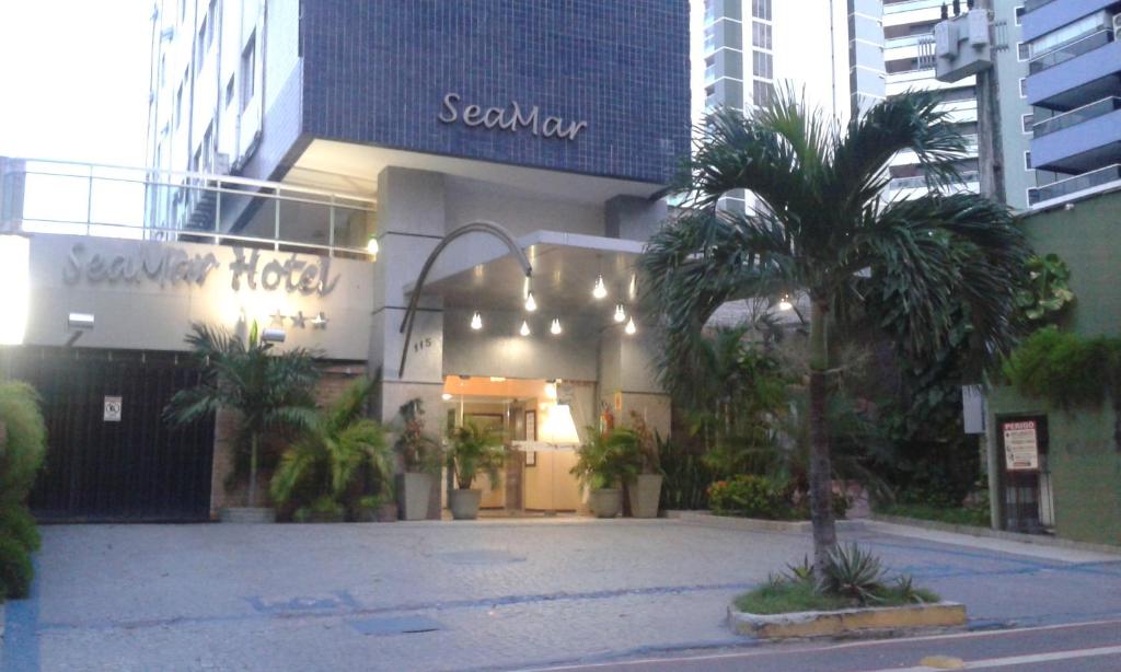 a building with a palm tree in front of it at Seamar Hotel in Fortaleza