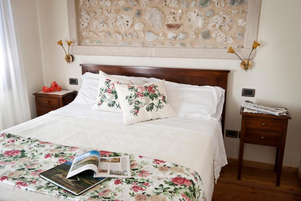 Un dormitorio con una cama con un libro. en Agriturismo Prime Gemme, en Nervesa della Battaglia