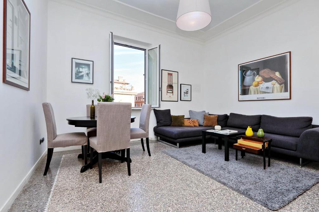 - un salon avec un canapé et une table dans l'établissement Piazza Capponi Apartment, à Rome