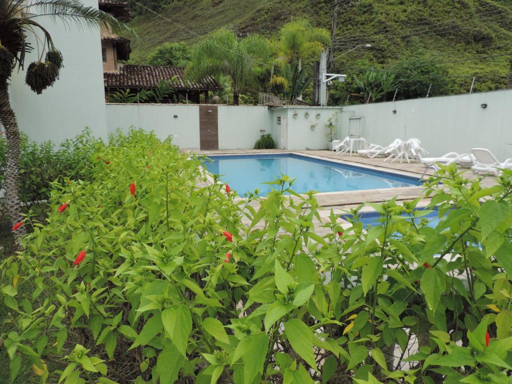 a swimming pool in a yard with plants at Casinha de Boneca em Juquey in Juquei