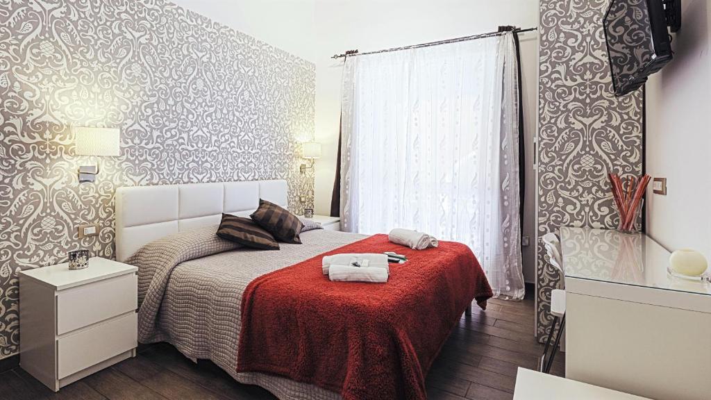ein Schlafzimmer mit einem Bett mit einer roten Decke in der Unterkunft Magic Double in Rom