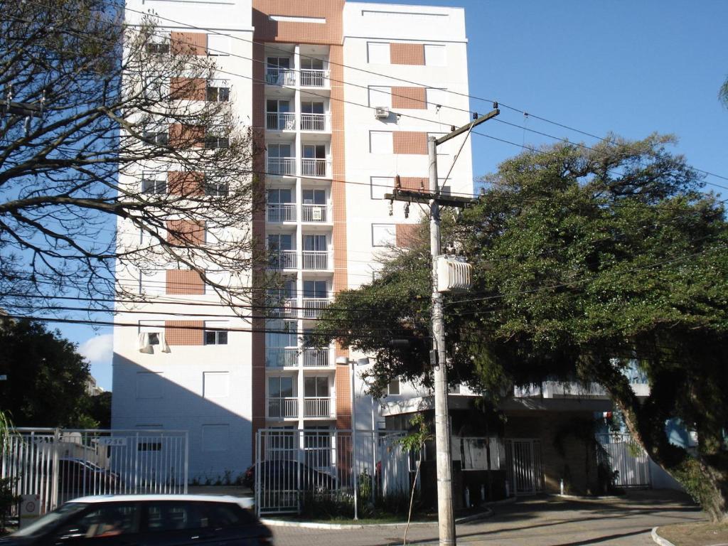 un edificio alto con un coche aparcado delante de él en Apartamento Cristal, en Porto Alegre