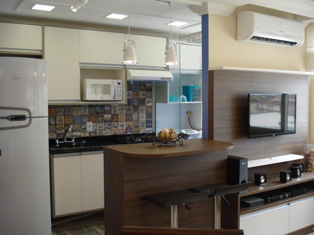 阿雷格里港的住宿－Apartamento Menino Deus，厨房配有柜台和冰箱。