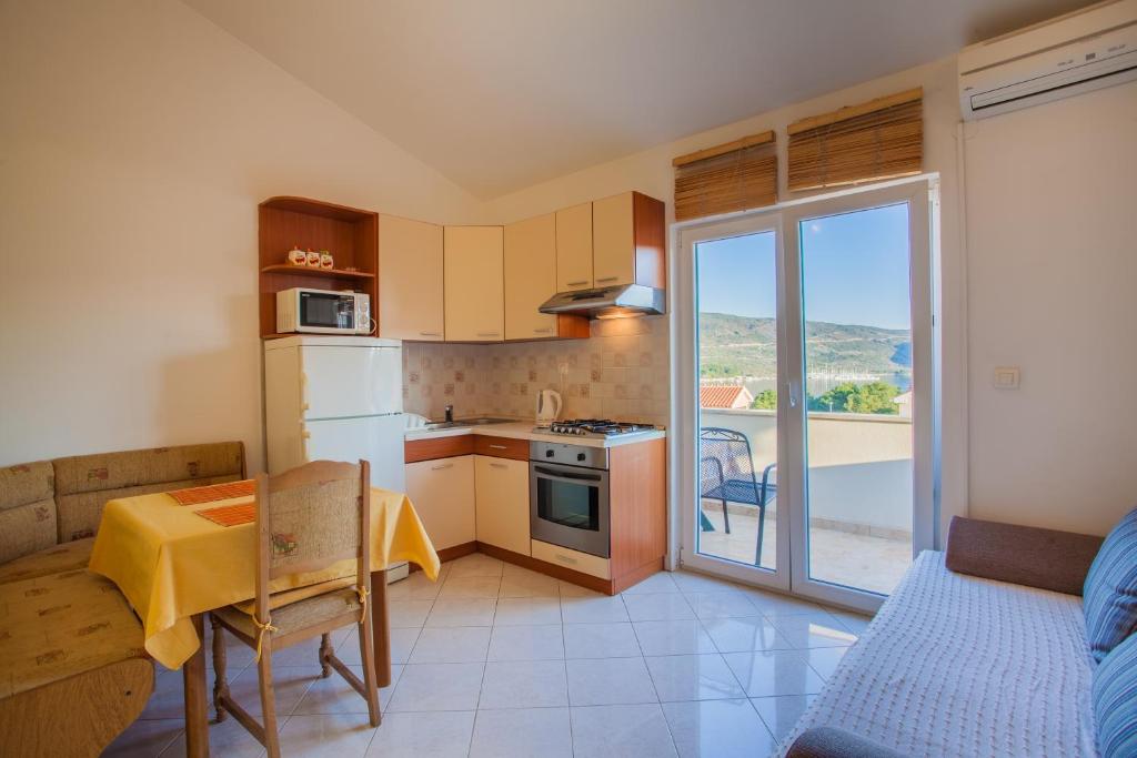 a small kitchen with a table and a dining room at Apartments Tatjana in Cres