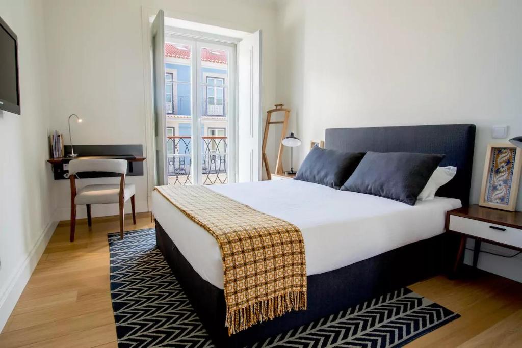 Un dormitorio con una cama, una mesa y un escritorio. en Madalena 133, en Lisboa