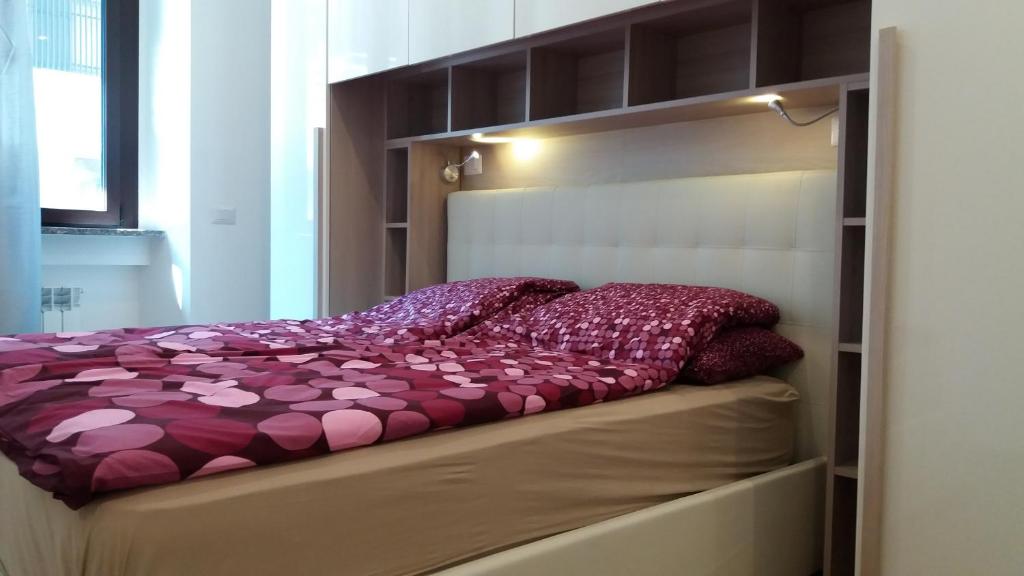 a bed with a purple comforter in a bedroom at Nice Livings Lazzaroni in Milan