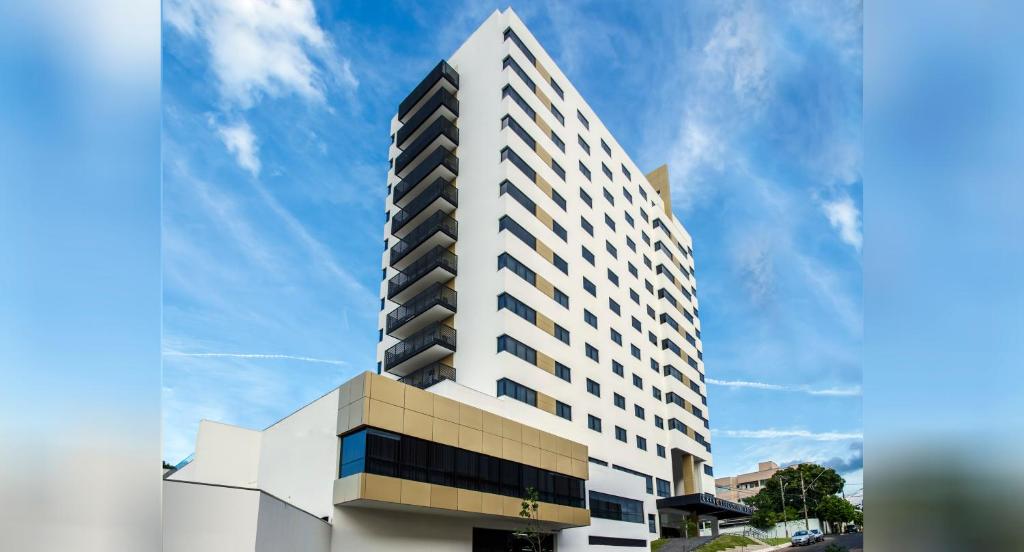 un grand bâtiment blanc avec un ciel en arrière-plan dans l'établissement Gran Executive Hotel, à Uberlândia