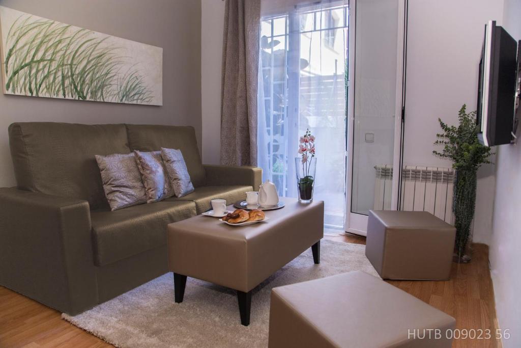 a living room with a couch and a table at Alcam Bailen Garden in Barcelona