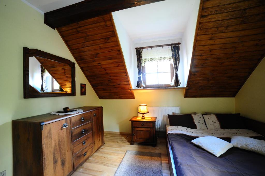 sypialnia z łóżkiem i komodą oraz 2 oknami w obiekcie Przystań Jaskółka w mieście Ruciane-Nida