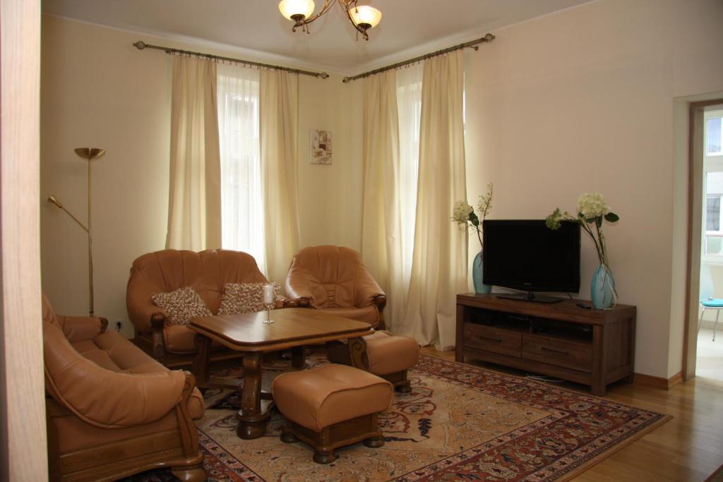 ソポトにあるApartament Diamentowy w Sopocieのリビングルーム(椅子、テーブル、テレビ付)