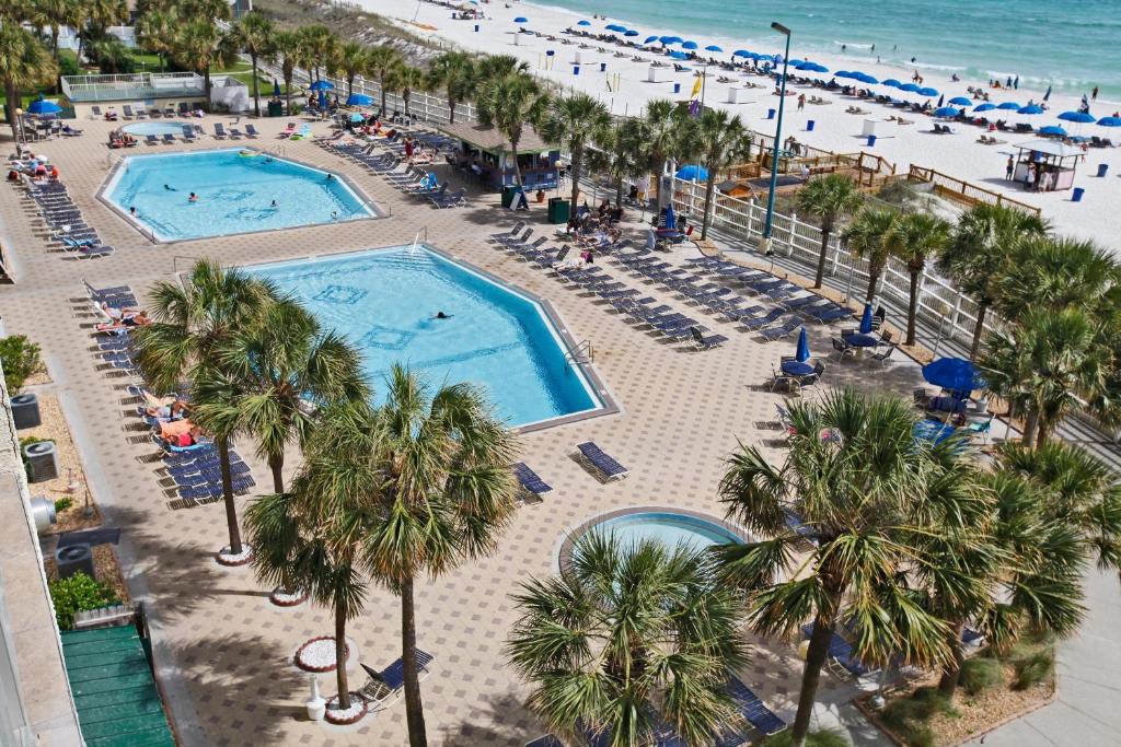 an aerial view of a beach with two pools and palm trees at The Summit by Panhandle Getaways in Panama City Beach