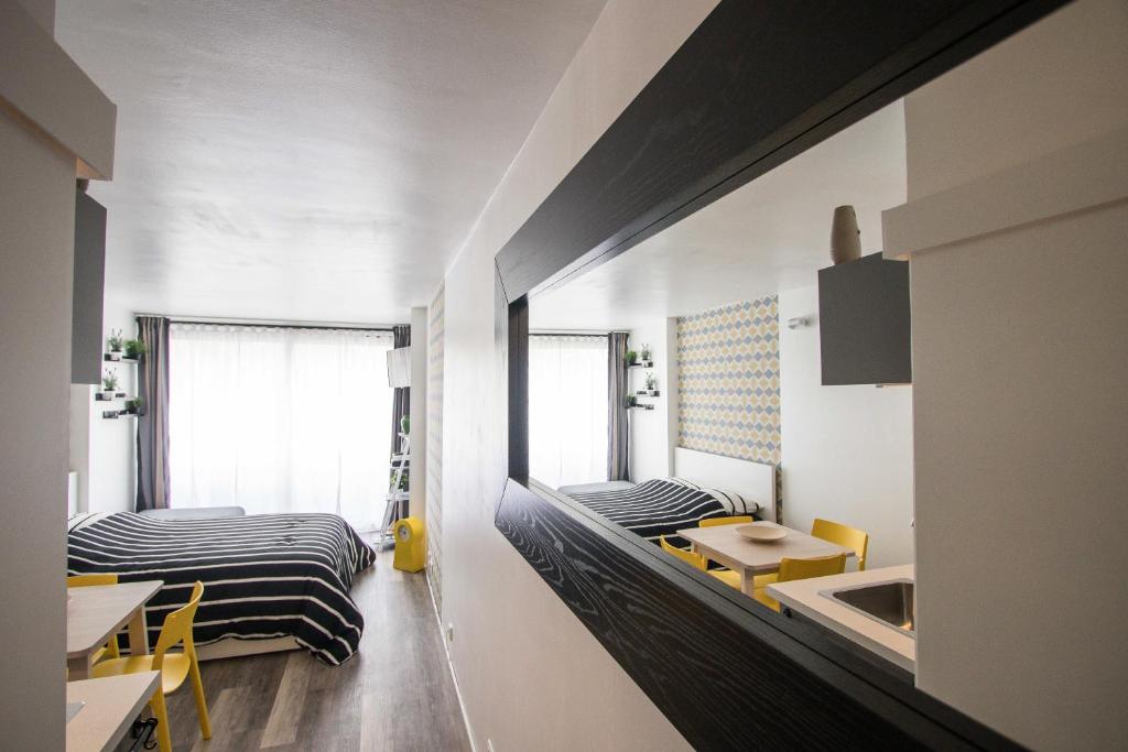 ロクブリュヌ・カップ・マルタンにあるStudio Couleur Soleilのベッド2台、テーブル、椅子が備わる客室です。