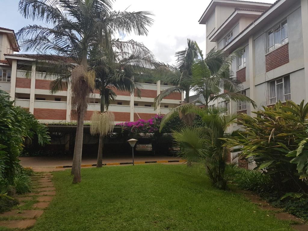 un patio con palmeras frente a un edificio en China Garden, en Nairobi