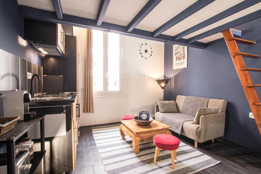ein Wohnzimmer mit Couch und Tisch in der Unterkunft Studio Mezzanine Bleu in Roquebrune-Cap-Martin