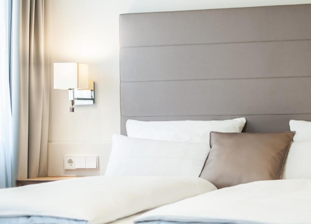 two beds in a hotel room with white pillows at Bayerischer Hof in Kitzingen