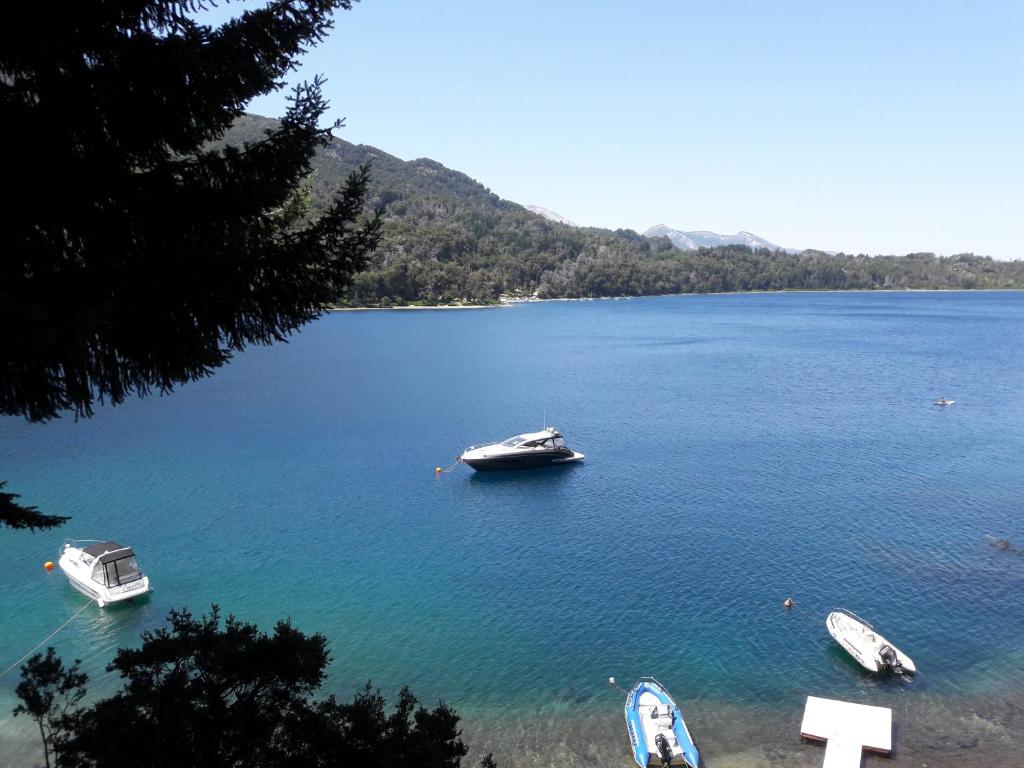 a group of boats in a large body of water at Dos Bahias Lake Resort in Villa La Angostura
