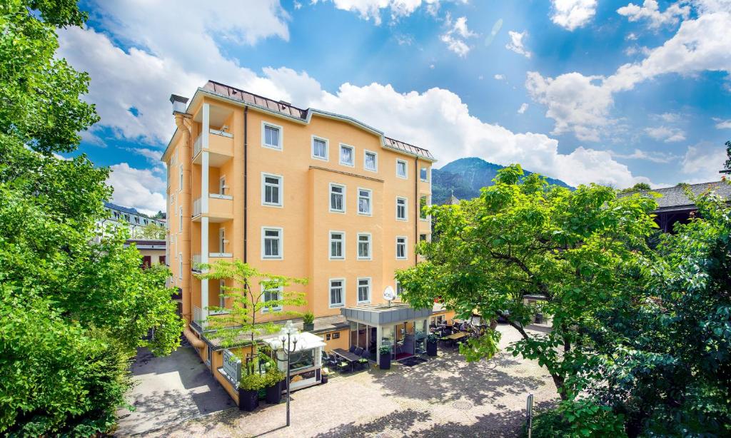 un gran edificio amarillo con árboles delante de él en Galerie Hotel, en Bad Reichenhall