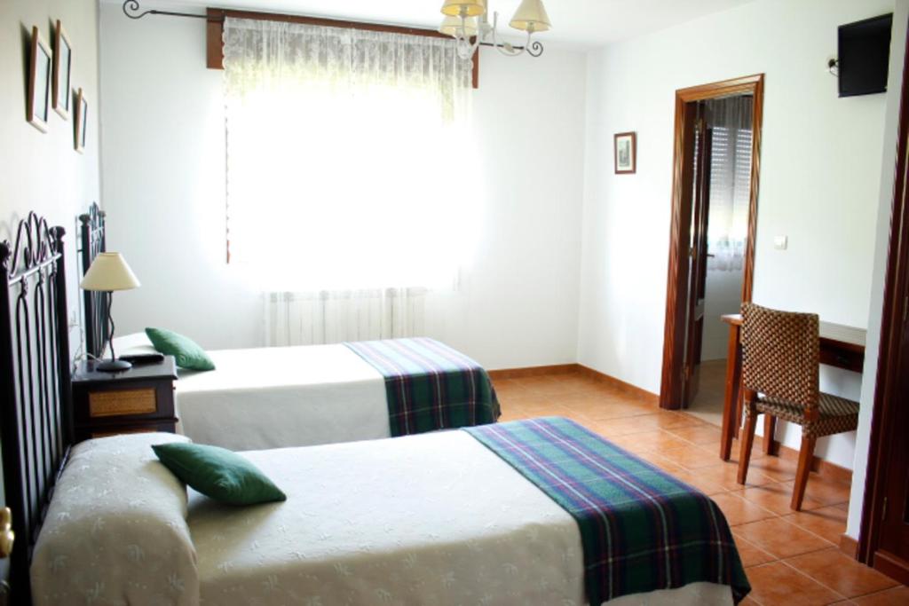 A bed or beds in a room at Pensión Mosende