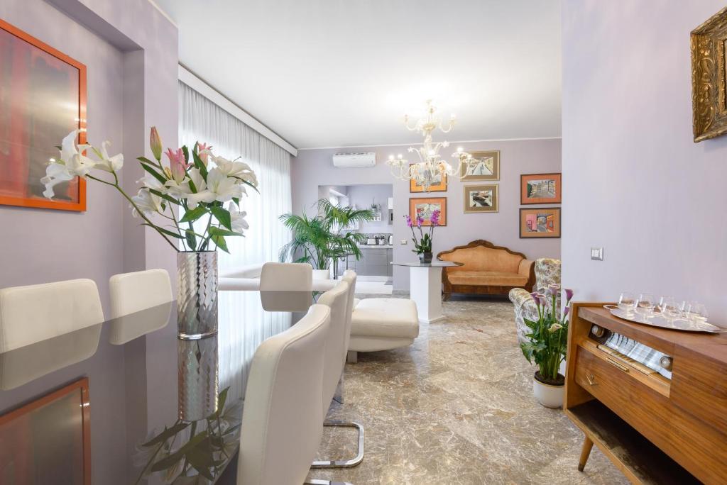 a living room with white chairs and a dining room at Luxury Property in Vatican Area in Rome