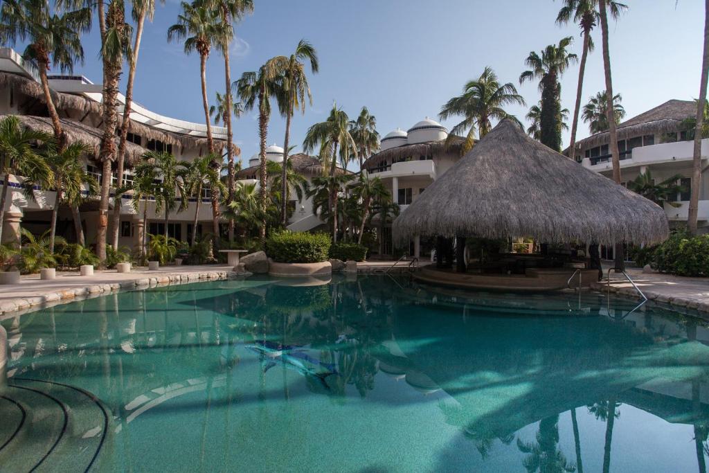 una piscina en un complejo con palmeras en Club Cascadas de Baja, en Cabo San Lucas