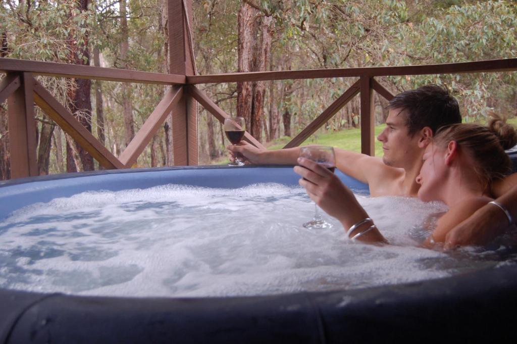 a man and a woman in a hot tub at Beyonderup Falls Adult Retreat in Nannup